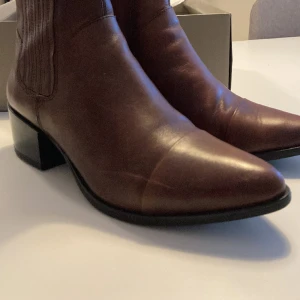 VagaBond bruna boots med liten klack  - Snygga skinnboots från vagabond. Har en repa på sidan av skon,  därav säljer för detta pris. Syns på bild 1. Annars i väldigt gott skick . Nypris 999:-