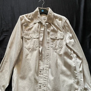 Jeansskjorta Zara - En ”jeansskjorta” från zara med knappar. Funkar både som overshirt och vanlig skjorta enligt mig! Storleken är M men kan passa L med. Använd 1-2 gånger och nypriset va 499 när jag köpte. Hör av er vid frågor.
