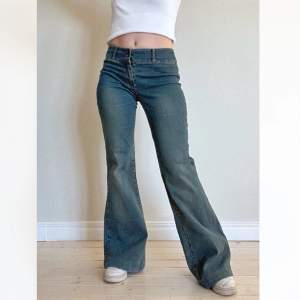 Lågmidjade jeans med stretch i grönblå tvätt. Utsvängda nedtill. Strl 34. Midjemått: 65 cm. Innerbenslängd: 76 cm. Fint skick! Se även mina andra annonser, 3 för 2 på allt! 💫