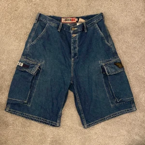 Blå Jorts - Ett par snygga jorts som jag inter använder längre. Mått: längden på hela byxan: 60cm, från grenen och ner: 27cm, midjemått (rakt över): 44 cm. Det funkar bra med skärp till. Köpare betalar för frakt.💕