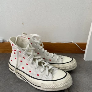 Vit Converse  - Vita Converse med röda puss munnar på. Endast använd 1 gång för 2 år sen på min student 