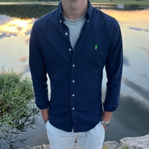 Ralph lauren skjorta - Marinblå Ralph lauren skjorta i storlek M (Slim fit) Sitter bra på modellen som är 184 cm. Perfekt nu till sommaren. Tveka inte att höra av dig vid minsta fundering