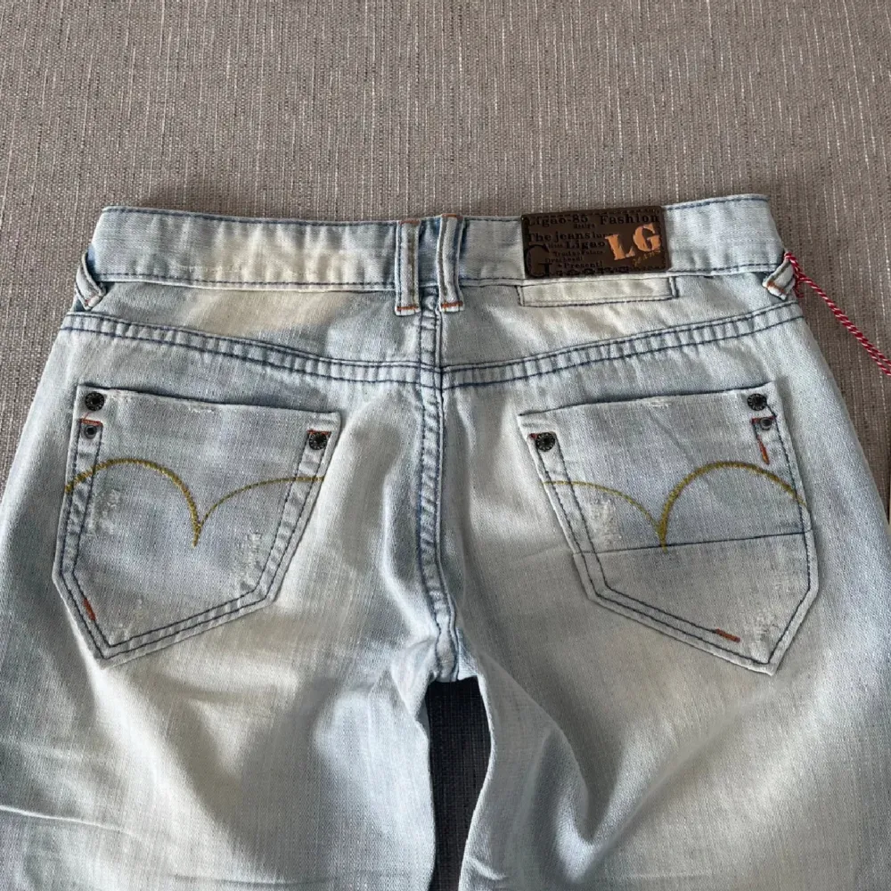 Ljusblåa lågmidjade utsvängda jeans som är helt nya! Har klippt av lappen men den följer med. Storlek W29, midjemått: 37cm innerbenslängd 86cm. Har vikt upp dem då de är för långa på mig. Köp nu går bra! 🥰. Jeans & Byxor.