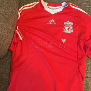 Liverpool matchtröja  - Säljer nu min Liverpool tröja som har hängt med i massa år. Skicket är dåligt på Carlsberg texten men resten av tröjan är bra.