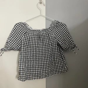 Rutig blus - Den hör gulliga blusen kommer från H&M och är i strl 146/152. Sitter fint och passar till det mesta. Den kan vara offshoulder.   Säljer för att den är för liten. 