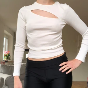 Topp med skärning - Vit ribbad topp med cool skärning. Passar bra såväl till fest och festival som middagar, beroende på hur det stylas! 🩷 Nyskick. Tryck gärna på köp nu! 