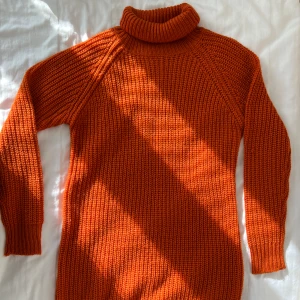 Orange brun stickad långtröja - En vacker stickad tröja som är långärmad & längden är lång till låret. Kan stylas upp som en klänning för er som annars bär S eller med ett par vackra jeans. Lång polokrage som viks ner vid halsen. Använt den en eller två gånger max.