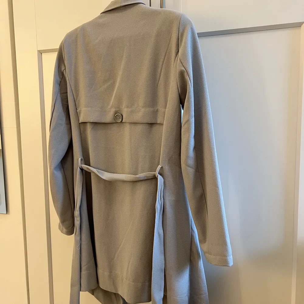 Snygg grå trenchcoat med knytband. Storlek XS, har fickor, mycket gott skick! Är 167 cm lång och normal S/M 💕. Jackor.