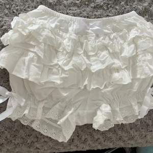 Vita frilly shorts  - jättefina vita frilly shorts som endast använts hemma ett par få gånger men aldrig utomhus!  De är en S, men är ganska töjbara och har elastiska kanter, så de är enkla att få på.  Har inga skador/ fläckar, men ser bara lite skrynklig ut på bilden.