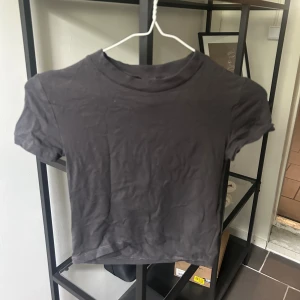 Mörkgrå t-shirt - Korta t-shirt från H&M i mycket bra skick. I storlek S men skulle säga att den passar XS bättre. 
