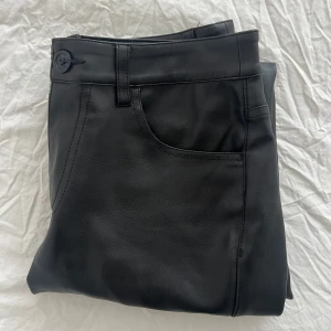 Skinnbyxor Bikbok - Svarta skinn byxor från BikBok.. Knappen har gått av men har sytt, så lätt att fixa annars helt nya använda ett par gånger men i nyskick. Inga skador. Köpta för 600 säljer för 250 eftersom de är i nyskick. Storlek 36.