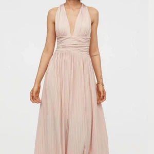 Balklänning  - En elegant långklänning från H&M i en ljus En balklänning rosa som har en djup v-ringning med korsade band i ryggen.💓💓 endast använd en gång!!