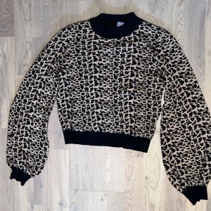 Leopard mönstrad långärmad tröja  - Leopard mönstrad långärmad tröja med lite puffiga ärmar och guld glitter. Från Lindex i storlek XS, använd någon enstaka gång men syns inte. 