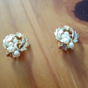 Clips örhängen guldfärgad med blad o vita pärlor. - Fina Clips örhängen guldfärgad metall med blad och vita pärlor.