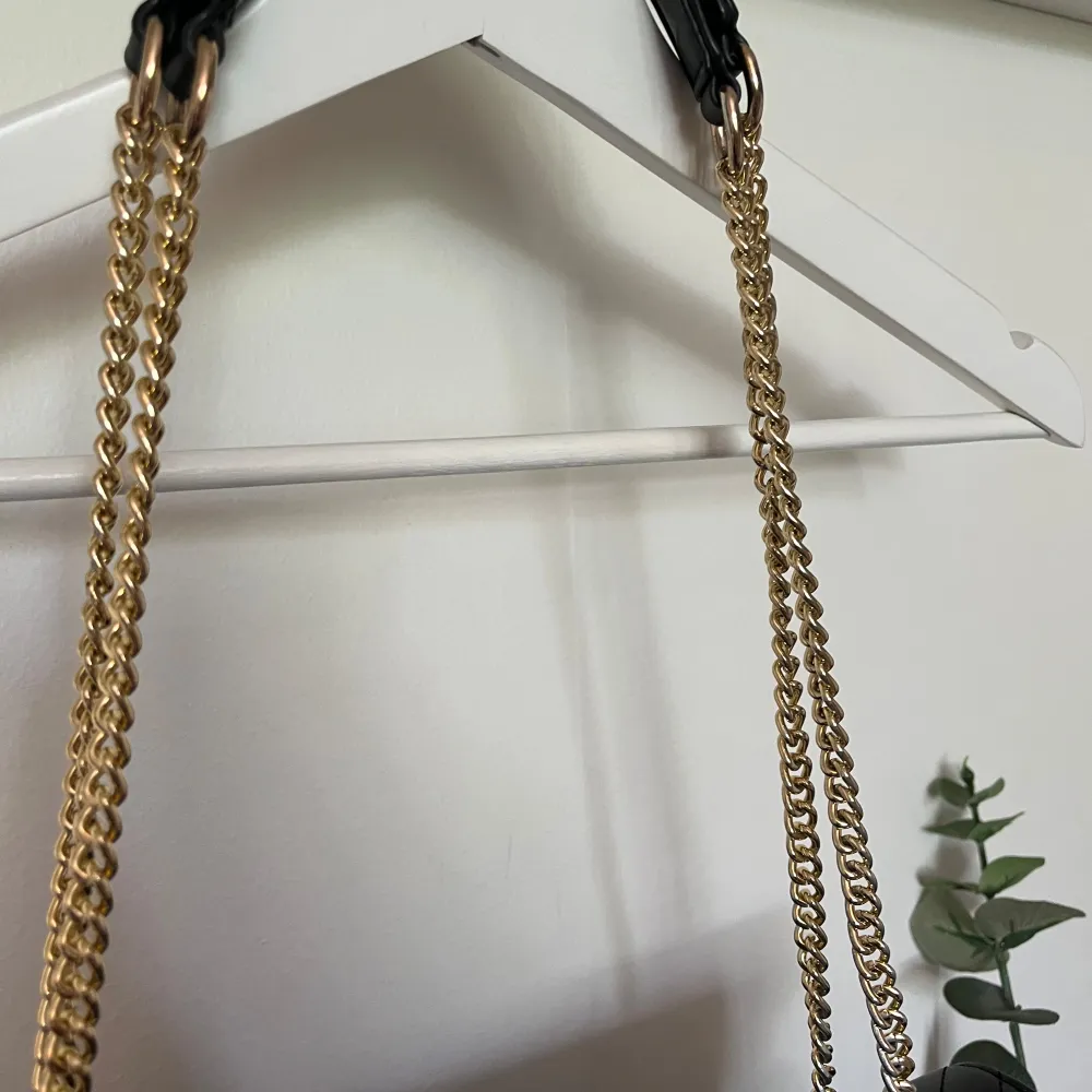 Svart väska med gulddetaljer, väskan är i måtten 28x22x6 Superbra strl Går att ha som crossbody eller på axeln 🌸. Laukut & Käsilaukut.
