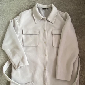 Tunn kappa  - Tunn ljusblå/grå kappa från Vero Moda i gott skick. Kort/medel längd. 