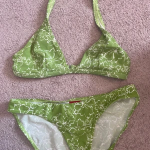 Bikini  - En grön bikini med vita blommor på