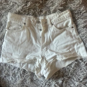 Krämvita jeansshorts  - Ett par riktigt snygga krämiga jeans shorts från H&M. Dem har en högre midja och har slitningar längs ner. Finns en liten grön fläck och på insidan så finns lite missfärgningar men då inget som syns. Säljer dem för att dem är för små för mig💕