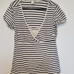 Randig amnings-t-shirt strl. M - Randig amnings-t-shirt från Hm i storlek L. Välanvänd och har blivit hål under armarna på båda sidor. Perfekt att ha liggandes som resev i skötväskan.   Tvättad i parfymfritt tvättmedel och utan sköljmedel.