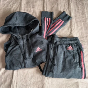 Grått Adidas mjukissett med rosa streck - Unikt Grått adidas sett med rosa streck. 💖💗Fint skick, lite små färg fläckar på byxorna men inget som syns tydligt. Annars superfint skick. Storlek S men passar XS. 