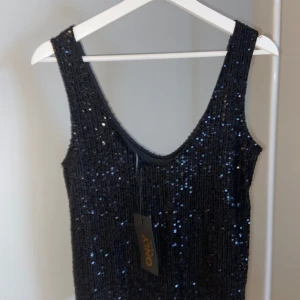 Paljett-tröja - En v-ringad tröja med paljetter i storlek M  Oanvänd med prislapp kvar   Finner inget att anmärka 