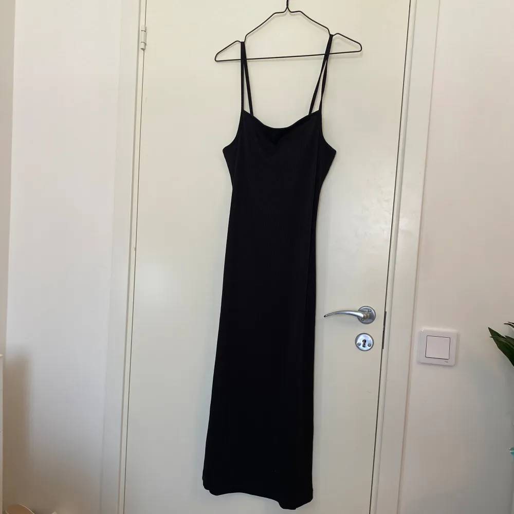 En svart ribbad klänning från H&M i storlek S. Öppen rygg med knytning . Klänningar.