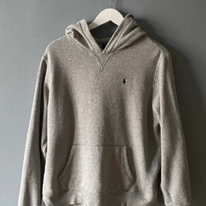 Polo Ralph lauren hoodie  - Grå hoodie från Polo Ralph Lauren. Tröjan har en luva och en känguruficka. Storlek L barn. Djurfritt och rökfritt hem.  Pris 300kr 