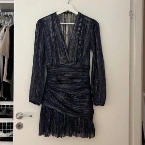 Maje Klänning - Maje Klänning köpt i München under WS 22/23. Nypris ca 3500 kr. Storlek 34. Helt slutsåld överallt, för mer bilder: https://www.saksfifthavenue.com/product/maje-runnylo-pleated-lamé-mini-dress-0400008641930.html 