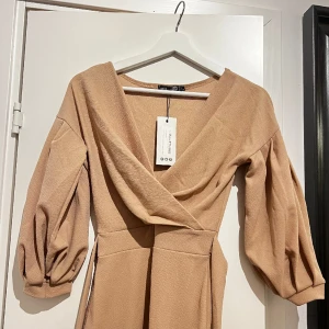 Klänning - Superfin klänning i beige/nude färg. Storlek 36. Köpt på Boohoo. Aldrig använd, prislapp kvar. Köparen står gör frakt alt. möts jag i centrala Göteborg 🫶