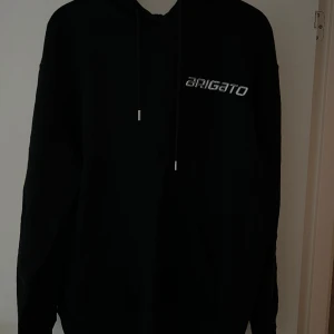 Axel arigato hoodie  - Svart Axel arigato hoodie med silvrig arigato text på bröstet och ett riktigt snyggt rymd tryck på ryggen. Är i storlek M. Säljer för 1200kr + frakt 