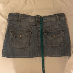 Minikjol - En minikjol med fina knapp fickor uppsydd 1-2 cm oxh säljes pfa den är för stor i midjan man kan bära den på två sätt (visas på bild) midjemåttet är 81