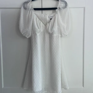 Klänning Missguided - Vit klänning med puffärmar perfekt till studenten eller i sommar! Storlek 38, köpt på Sellpy i mycket bra skick!🤍Säljer pga för stor.