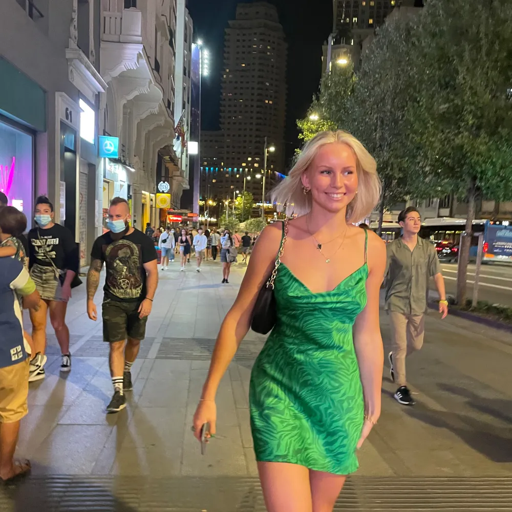 En kort grön glansig klänning från en butik i Madrid som jag ej kommer ihåg namnet på. Jag är 170 cm och ni ser ju på bilderna hur lång/kort den är på mig. Hör av er vid frågor:). Klänningar.