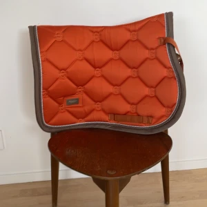 Es Schabrak! - Fint schabrak från Equestrian Stockholm. Äldre modell som jag TROR inte säljs längre. Färgen är orange. Storleken ponny💕