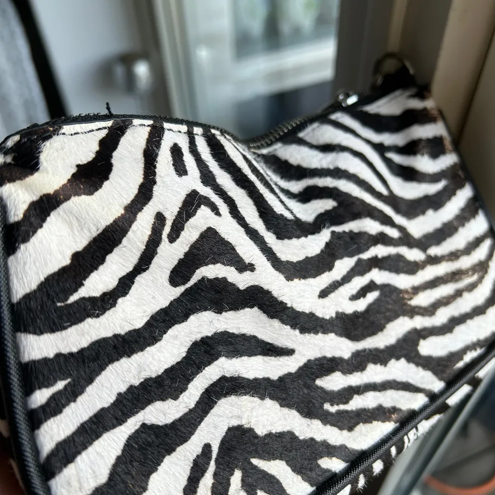 Superfin väska i zebra mönster från Zara. Köpte väskan för några år sedan och den är använd under en sommar. Den är i bra skick men mönstret har skavts bort lite på ena sidan. . Väskor.