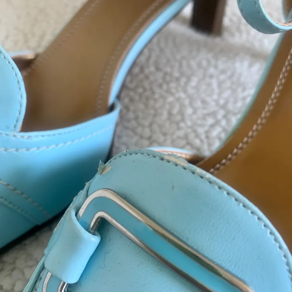 Otroligt vackra låga klackskor / kitten heels i en fin ljusblå färg med spänne. Aldrig använda, men finns några små prickar och skador på ena skon (se bild), det syns knappt och stör inte användningen. Säljer även storlek 38 i annan annons.. Skor.