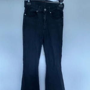 Svarta utåtsvängda jeans  - Svarta utåtsvängda jeans. Jeansen har vissa fläckar på sig och är slitna. Storlek 32/S, fast det är väldigt stretchiga i materialet. Säljer då det inte passar mig!
