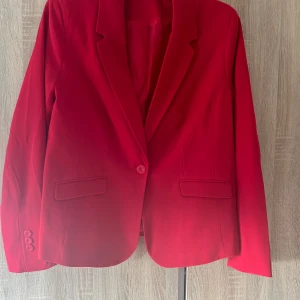 Röd kavaj - En läcker röd kavaj i strl 44 använd endast en gång så den är som ny.