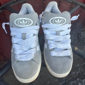 Grå adidas campus 00s - Säljer mina adidas campus 00s i storlek 38! Skorna har använts i ca 3 veckor. Snörena är även lite smutsiga, men går enkelt att göra rent i t.ex tvättmaskin! Priset går att diskutera! 