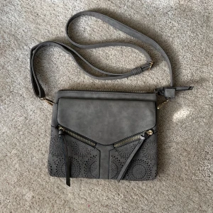 Handväska <3 - Så galet snygg handväska, thriftad men i nyskick! inga tecken på användning och aldrig använts utav mig ❣️mått: 25x20 cm. färg visas bäst på sista bilden🙌har många fack samt mindre fack som syns på bilderna🫶🏻bandet är justerbart! använd gärna köp nu💌