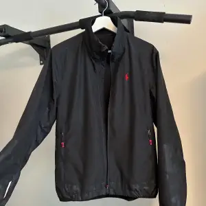 En Windbreaker/Polo, tunnare jacka. Mycket fräscht släpp från Ralph Lauren, polos med röd detalj på nacken produceras inte längre och är väldigt eftertraktade. Säljer för att den slutat passa mig. Nypris runt 1300kr, mitt pris 849kr.