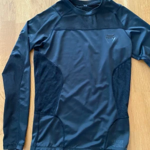 Venom rashguarf - Säljer en venom rashguard/ träningströja. Kan användas om man kör bjj eller liknande, men kan även användas för vanlig träning. Den är lik under armour tröjorna. Har använts 1-2 gånger och är i bra skick. Pris kan diskuteras via snabbafffär