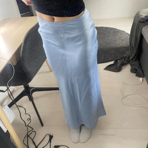 Blå maxikjol i satin - Blå maxikjol i satin. Använd en gång. Bra skick. Säljer för att den är för liten för mig