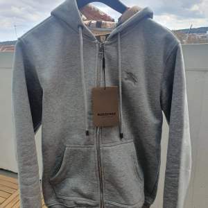 En riktigt fräsch 1:1 grå Burberry zip up hoodie. Den är så gott som ny och är i topp skick. Alla tags finns. Ko.pi.a.  Storlek-M Har du någon fundering är det bara att fråga👍