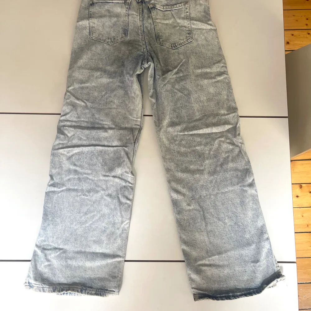 Stentvättademede ljust gråblå jeans med vida ben och ett par revor/hål (inte slitage utan nött look). Skrynkliga på bilden. . Jeans & Byxor.