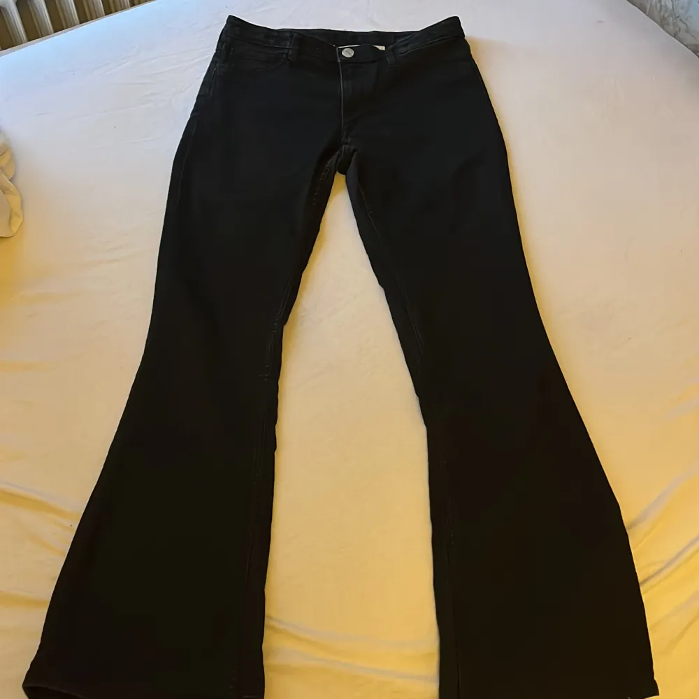 Midja = 35 cm, hel längd = 95 cm, svarta low waist byxor som är utsvängda längst ner, använda men bra skick. Jeans & Byxor.