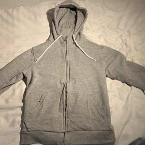 Grå zip up hoodie - Säljer denna grå zip up hoodie från etirel. Skick 10/10