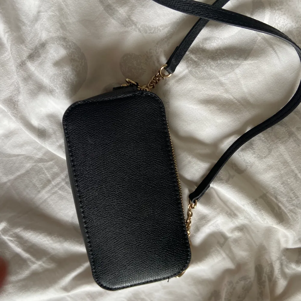 Liten svart handväska med gulddetaljer  Nyskick  . Väskor.