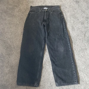 Svarta/mörkgrå baggy jeans från Vailent - Säljer mina svarta/mörkgrå baggy jeans från Vailent då jag vuxit ur de. De är köpta på Carlings för 700kr.  Skick: 8/10 de är lite slitna längst ner på benen och är lite slitna på sidan av ena låret (se bild 3 och 4). Hör av dig vid frågor! :) 