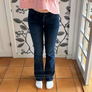Lågmidjade Wrangler-jeans. Fint skick. Mjukt stretchigt material. Storlek 27x32. Midjemått: 35 cm. Innerbenslängd: 80 cm.